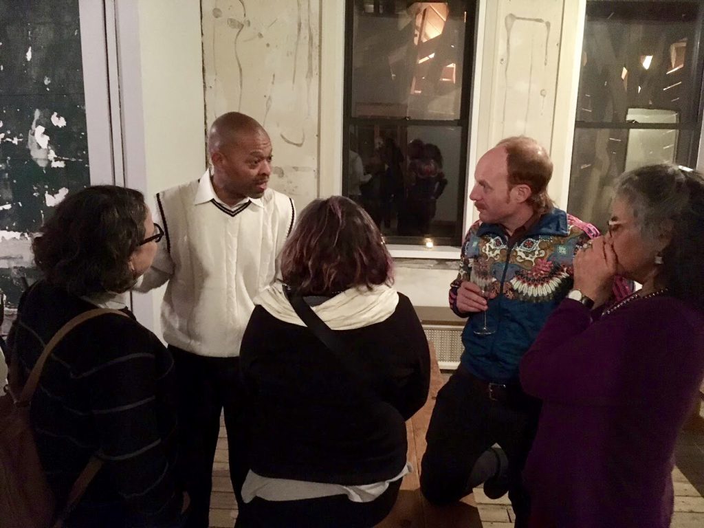 A group of five people talk about the dinner experience. Among them is Elbert Ford. Photo by Tricia Van Eck.