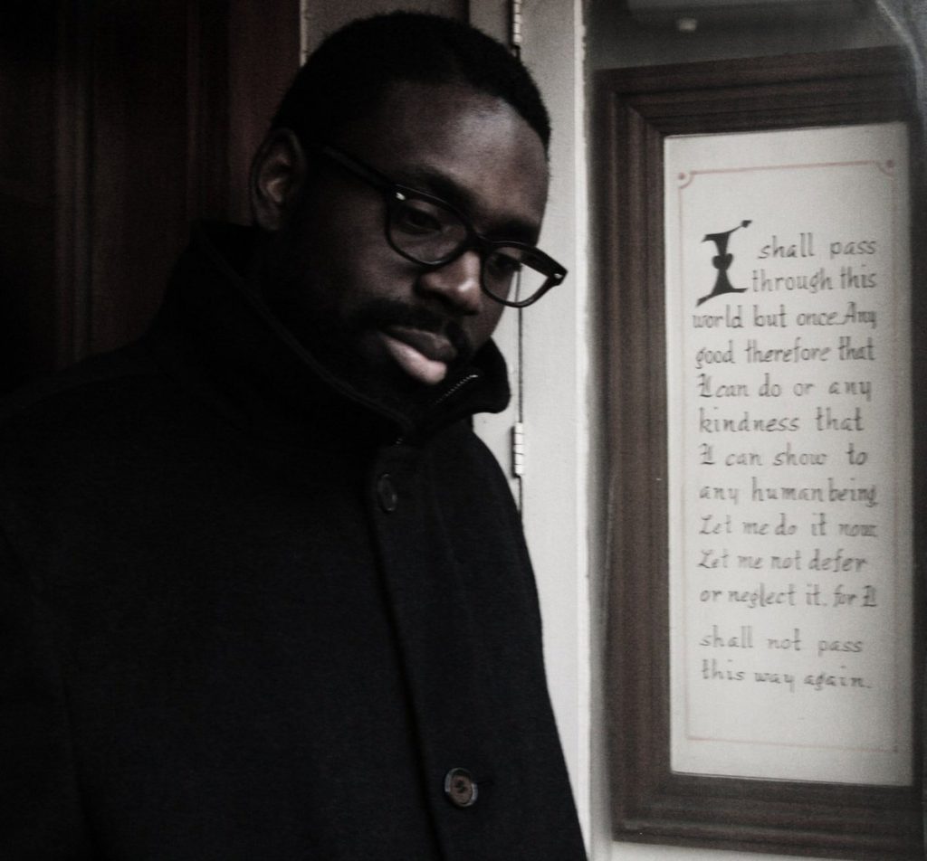 The album cover for “Starfish Time” is a photograph that shows the artist, as a younger man, on the left side of the image and, on the right side, script within a brown wooden frame. The artist wears black glasses and a black coat that is buttoned all the way up. He tilts his head toward the camera and looks toward the ground. The text reads: “I shall pass through this world but once. Any good therefore that I can do or any kindness that I can show to any human being, let me do it now. Let me not defer or neglect it, for I shall not pass this way again.” Courtesy of the artist.