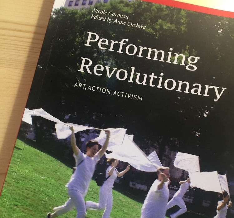 Image shows the cover of the book "Performing Revolutionary: Art, Action, Activism." The cover shows several people wearing white waving white flags while running down a hill. in Grant Park.