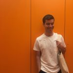 Writer Jared Quinton standing in front of an orange wall.