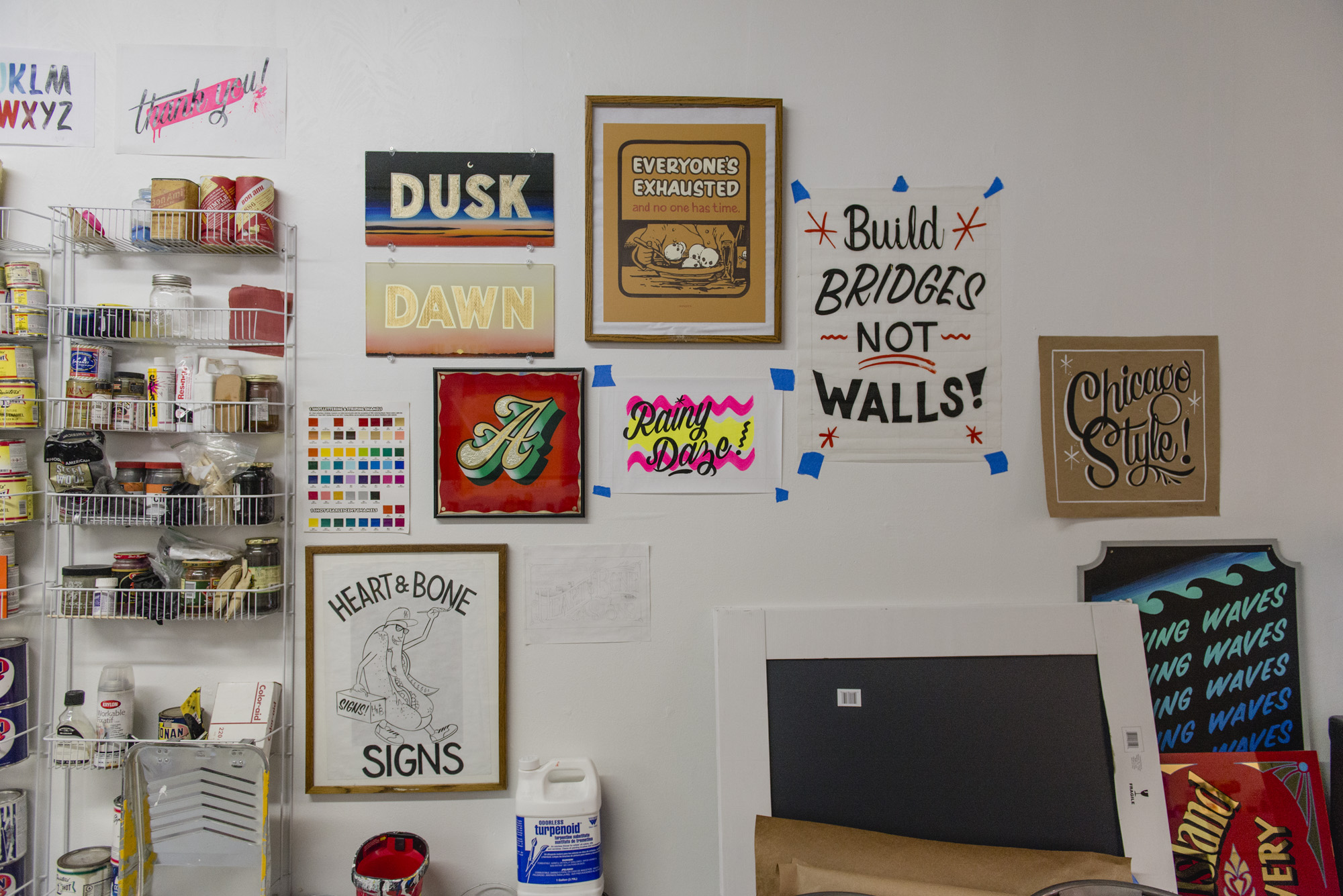 Image: Kelsey and Andrew's studio space, displaying examples of hand lettering and gold leaf work with commonly used materials and tools. Photo by Ryan Edmund Thiel.