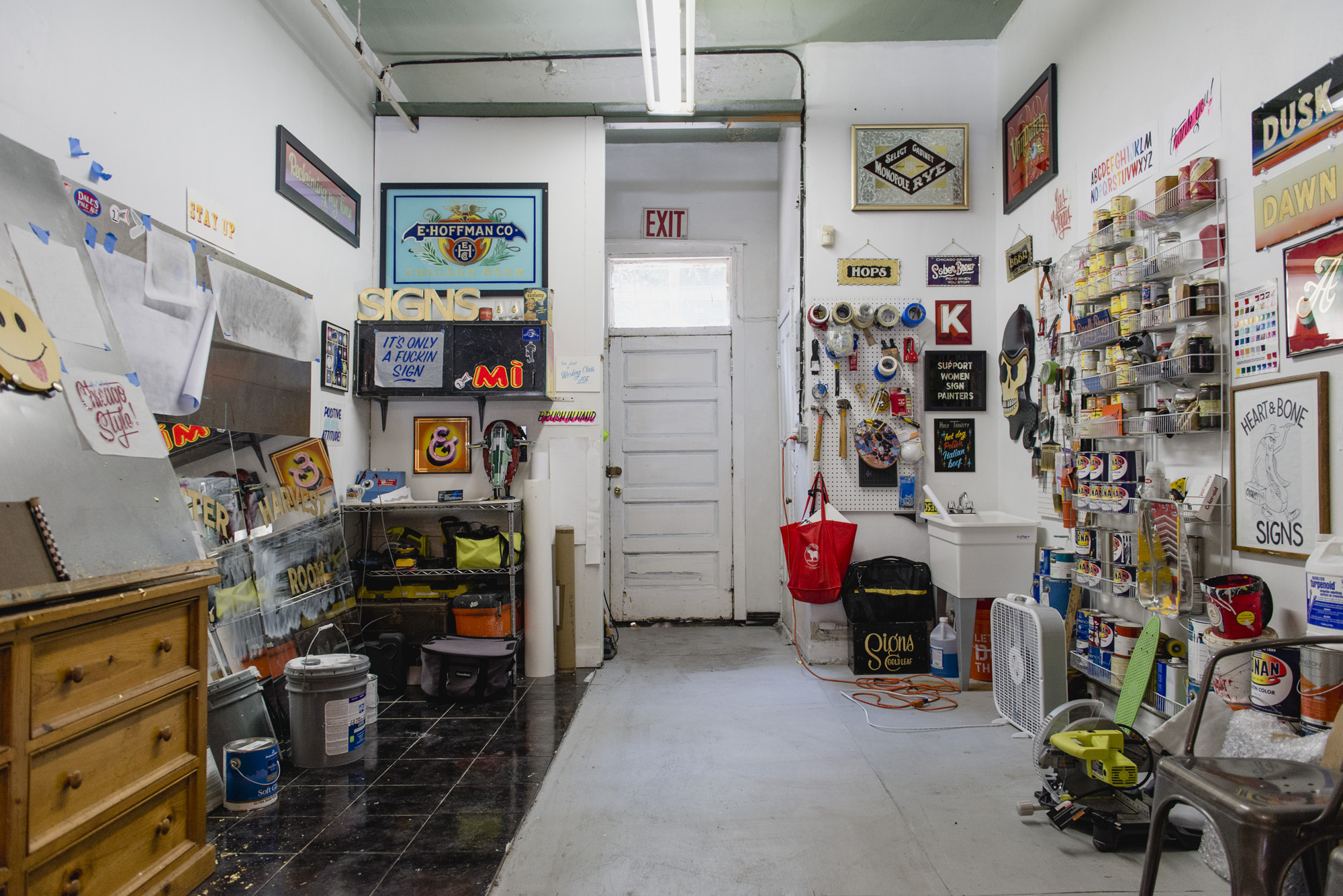 Image: The back end of Kelsey and Andrew's gallery space, filled with various tools and art supplies. This space functions as a studio space for their business Heart & Bone, Gold Gilded and Hand Painted Signs, which has been in existence since 2012. Kelsey and Andrew's work has local, national, and global reach. Photo by Ryan Edmund Thiel.
