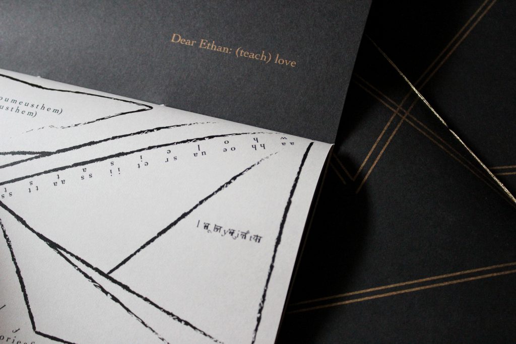 Image: Udita Upadhyaya’s book “nevernotmusic” (detail), showing part of the score, “Dear Ethan: (teach) love.” Part of one page-spread is visible, with opaque black paper on the upper page (where the score’s title appears in gold type) and with whitish vellum on the lower page (with gestural lines, triangles, and text in English and Hindi, printed in black ink). In the background, beyond this copy, is part of the front cover of two other copies, with gold stitching and straight gold lines on black paper. Photo by Caleb Neubauer.