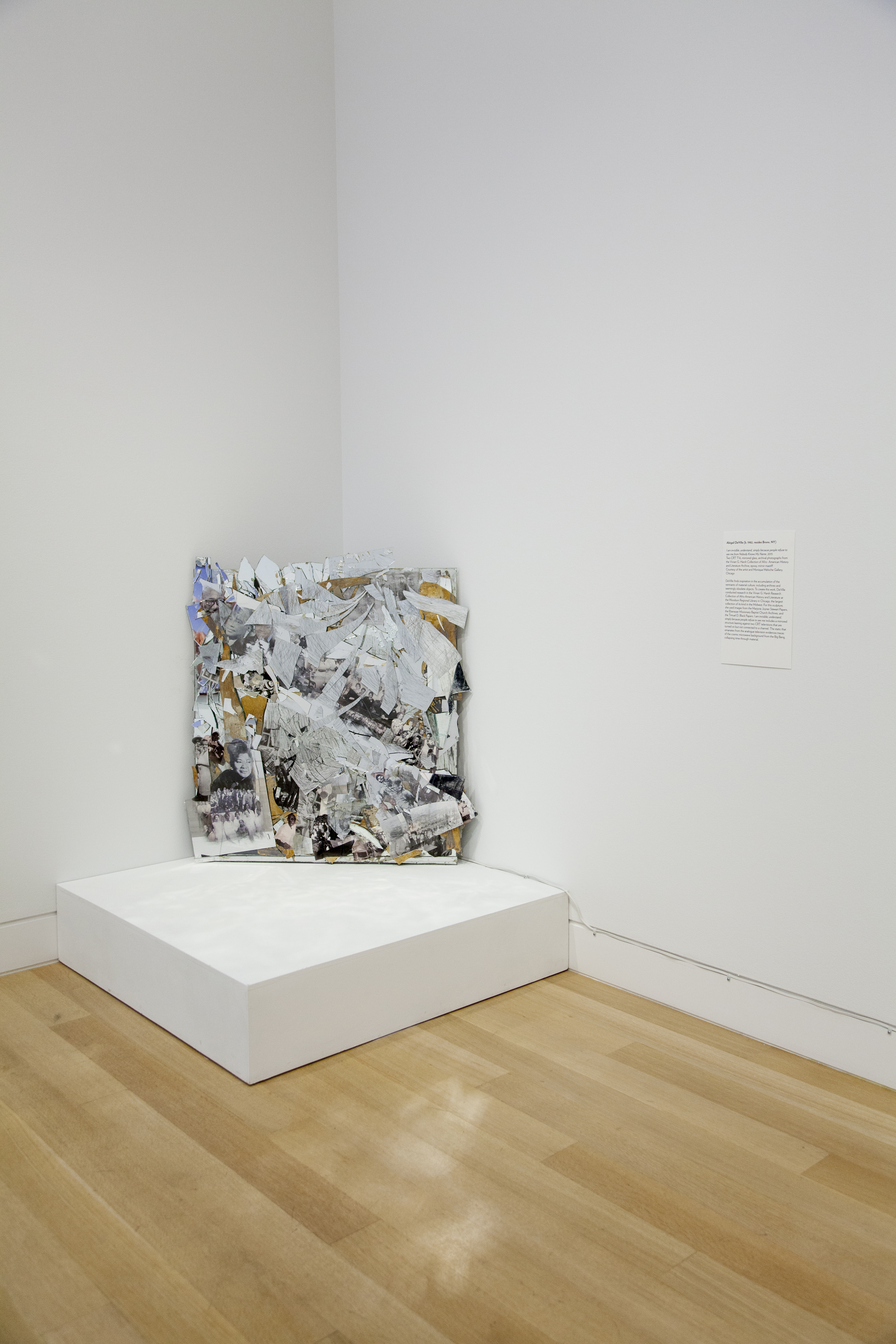 Image: Abigail DeVille, I am invisible, understand, simply because people refuse to see me from Nobody Knows My Name, 2015 [installation view]. A collage of shattered glass and imagery covers a gutted television leaning against the corner of a room. Image courtesy of DePaul Art Museum.