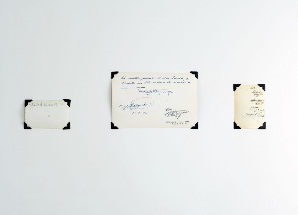 Image: Andre Keichian, 'Salt in the I' (detail), 2019. View of signatures and writing on the reverse sides of three photographs from Keichian's family album, as part of the exhibition installation at table. Photo by Kim Becker. Image courtesy of Kyle Bellucci Johanson.