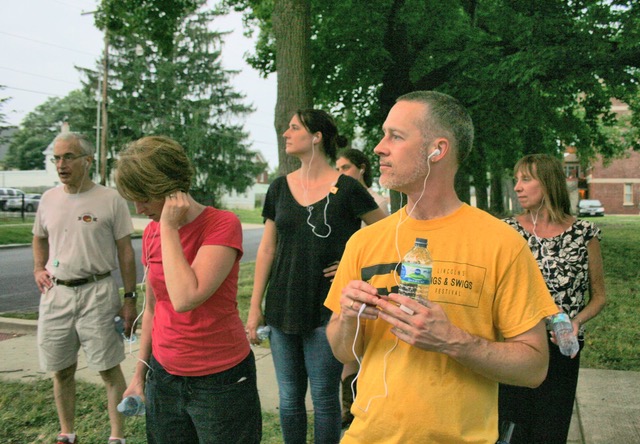 Image: Enos Park Uncovered: Audio-Walk created by Astrid Kaemmerling in 2017. Participants walking the neighborhood while listening to the audio-walk being led by Astrid Kaemmerling, Location: Enos Park, IL. Photo by Job Conger.