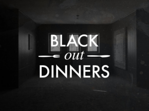 Image of a very dark room, three faint windows can be made out. White text on top of the image says "Black Out Dinners" with a small fork and knife graphic. Photo courtesy of 6018North.