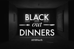 Image Description: Image of a very dark room, three faint windows can be made out. White text on top of the image says "Black Out Dinners" with a small fork and knife graphic. Photo courtesy of 6018North.]