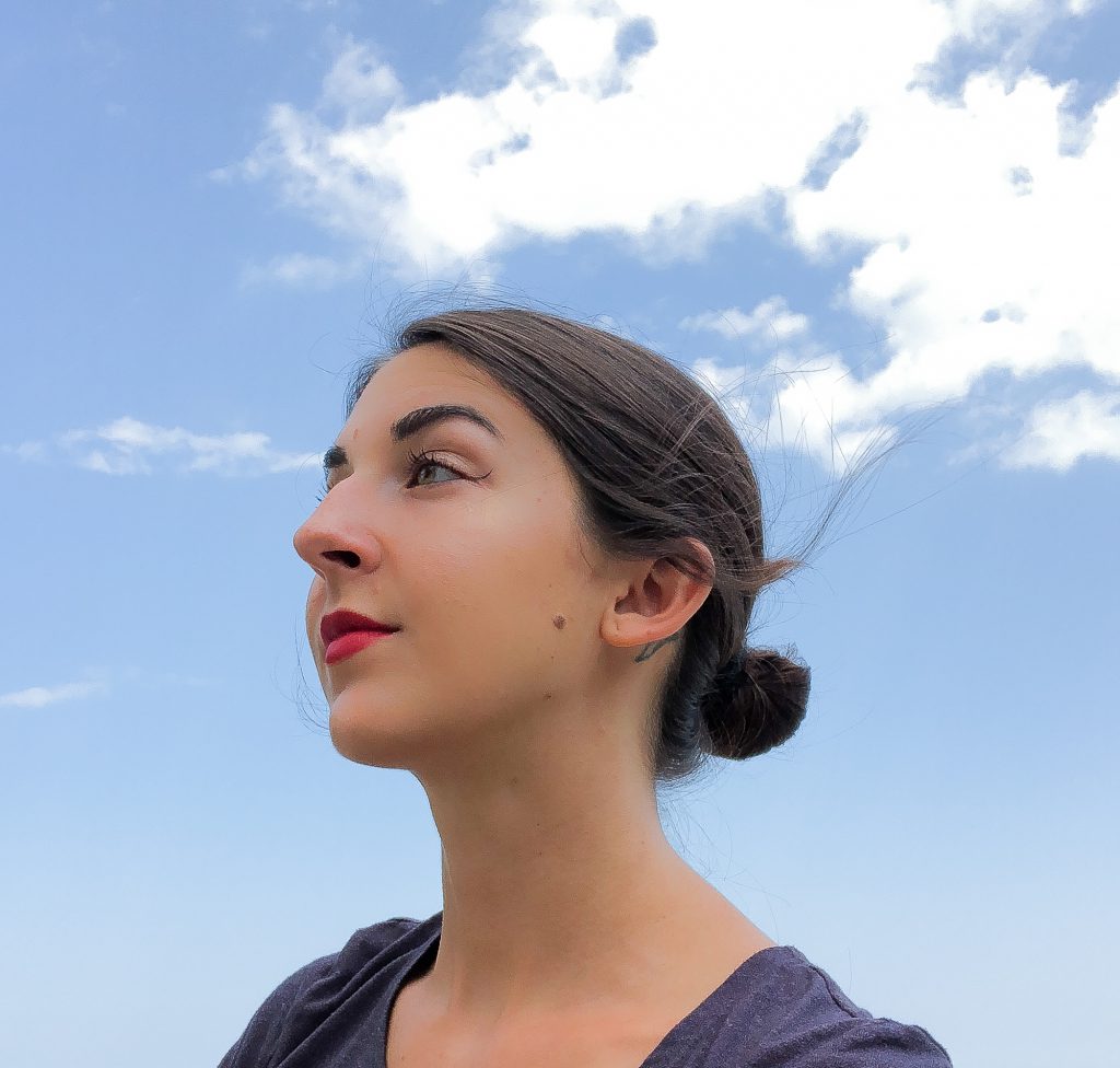 Image: A portrait of S. Nicole Lane, who is looking left against a background of sky.