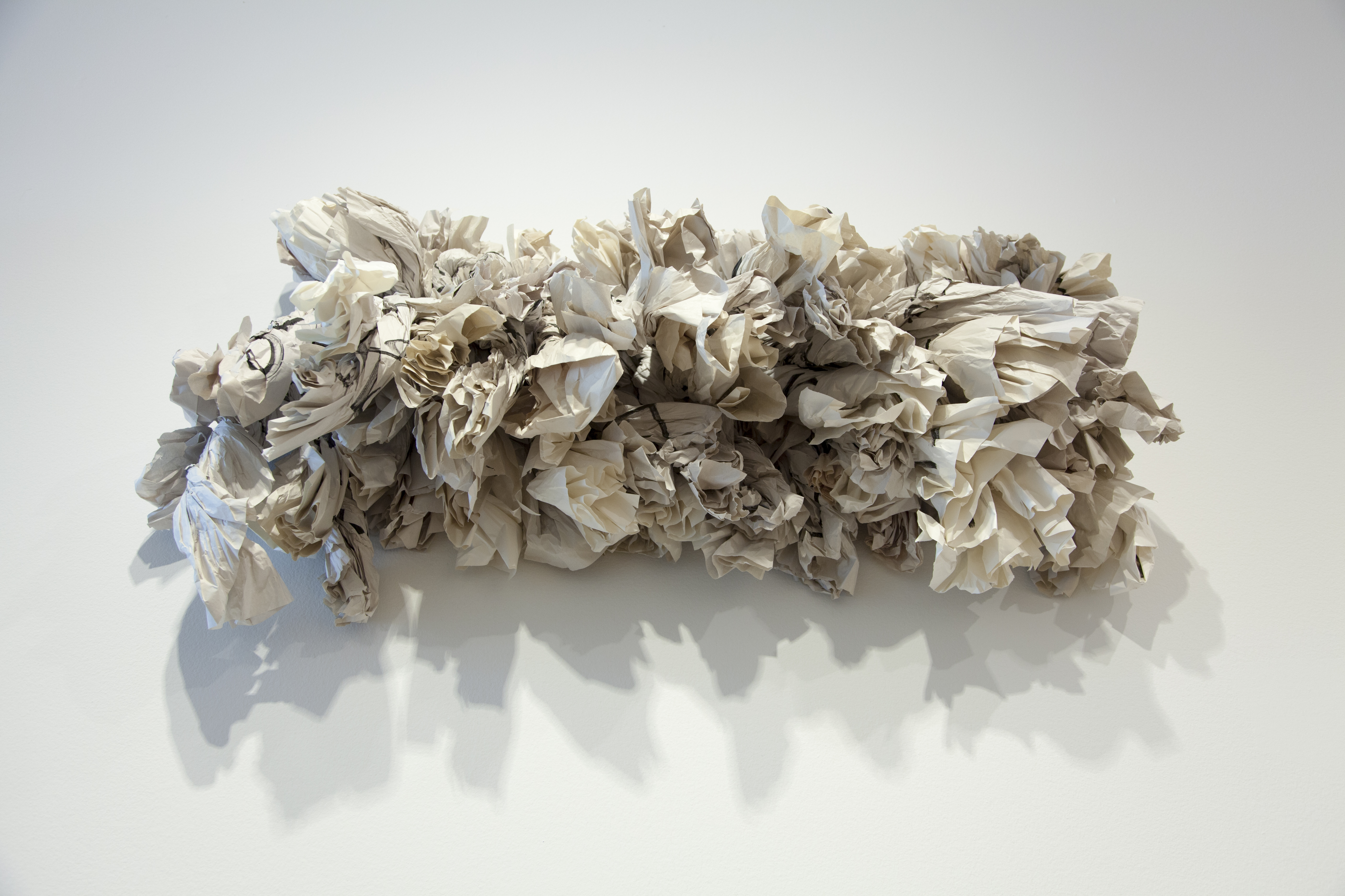 Image: Maren Hassinger, Fight the Power, 2016 [installation view]. A panel of tightly rolled papers extending from the wall. Image courtesy of DePaul Art Museum.