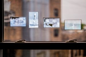 Andre Keichian, 'Salt in the I' (detail), 2019. View of negatives from Keichian's family photo album adhered to a glass window as part of the exhibition installation at table. Photo by Kim Becker. Image courtesy of Kyle Bellucci Johanson.