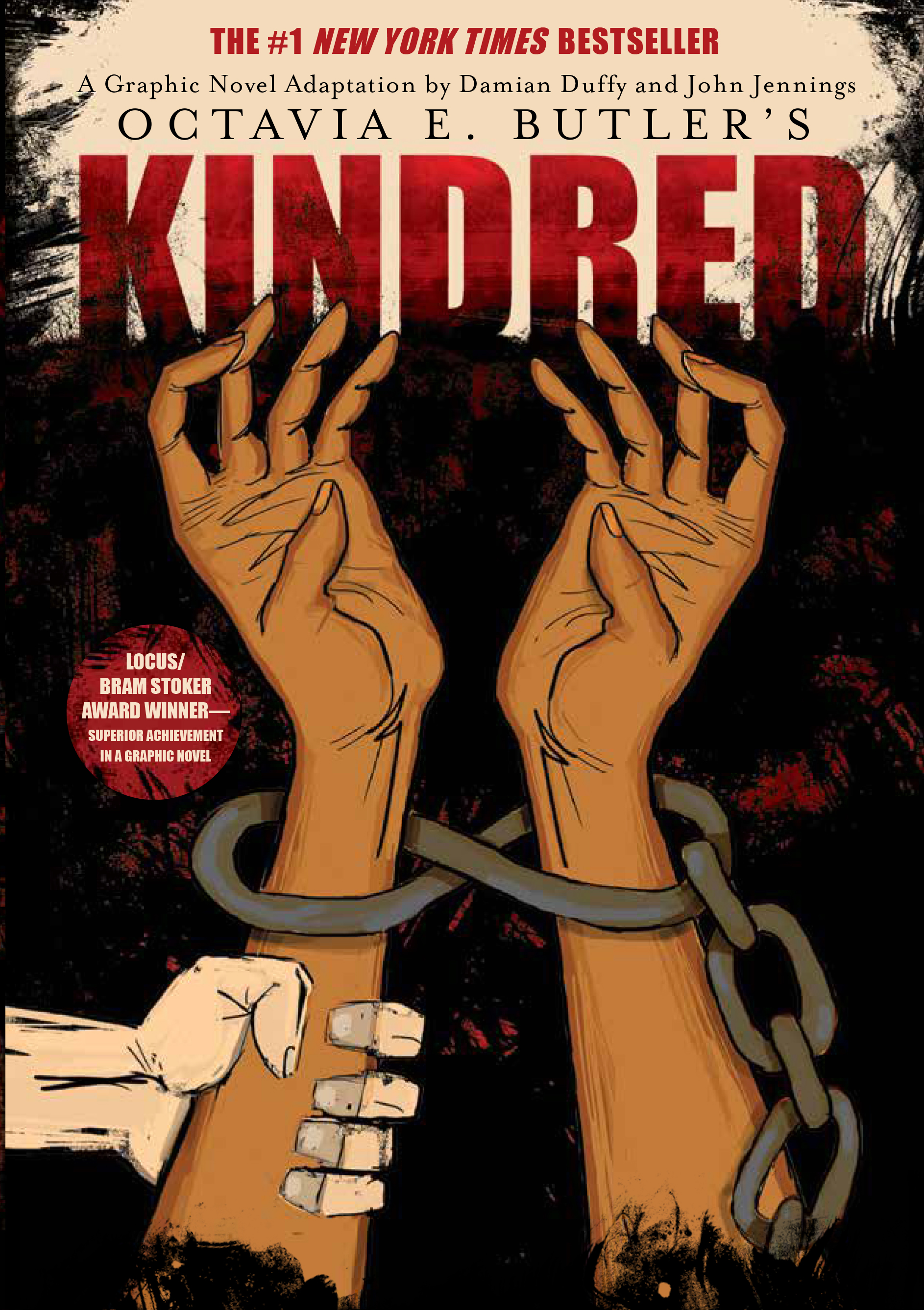 Image: The cover of “Kindred: A Graphic Novel Adaptation” features two brown arms reaching upward, with chains around the wrists against a black and red backdrop. A white hand grabs the left arm. Image courtesy of Damian Duffy.