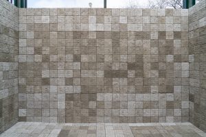Image: Selva Aparicio, Entre Nosotros (Among Us), 2020. Concrete tiles cast from human cadavers. The image shows the piece installed. Various tones of grey, concrete blocks form a grid on three sides like walls, as well as an additional fourth side as a floor. Photo: Robert Chase Heishman. Image courtesy of the artist.
