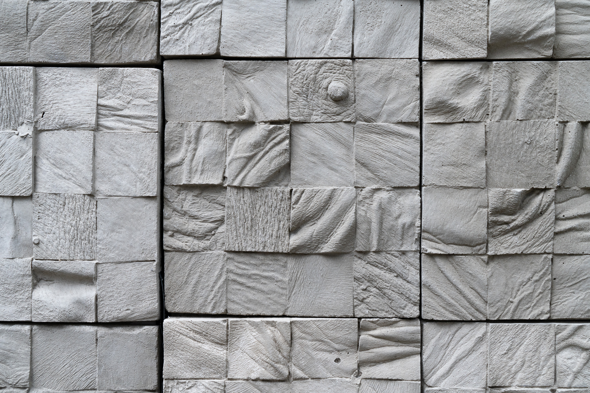 Featured image: Selva Aparicio, Entre Nosotros (Among Us) Detail, 2020. Concrete tiles cast from human cadavers. The images show a close up of the piece, showing details of a grid of square, concrete blocks. Each block has different folds, and one shows a nipple, all cast from human parts. Photo by Robert Chase Heishman. Image courtesy of the artist.