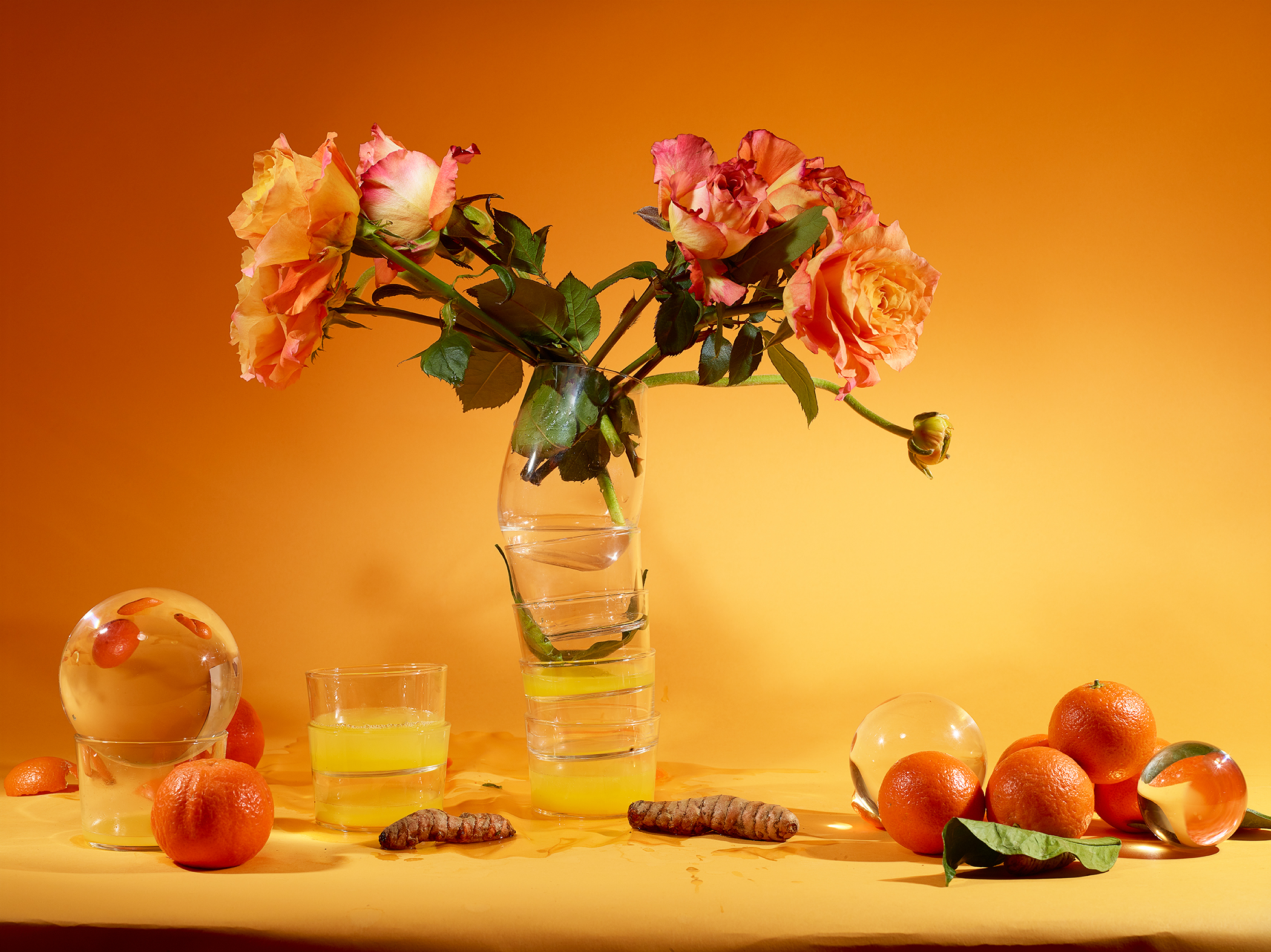 Featured image: The Six, 2020 by Marzena Abrahamik. A photograph of a still life of a orange and red bouquet of flowers on an orange-yellow table. On the table also sits oranges and various plant parts. The background dis also orange-yellow. Image courtesy of the artist.