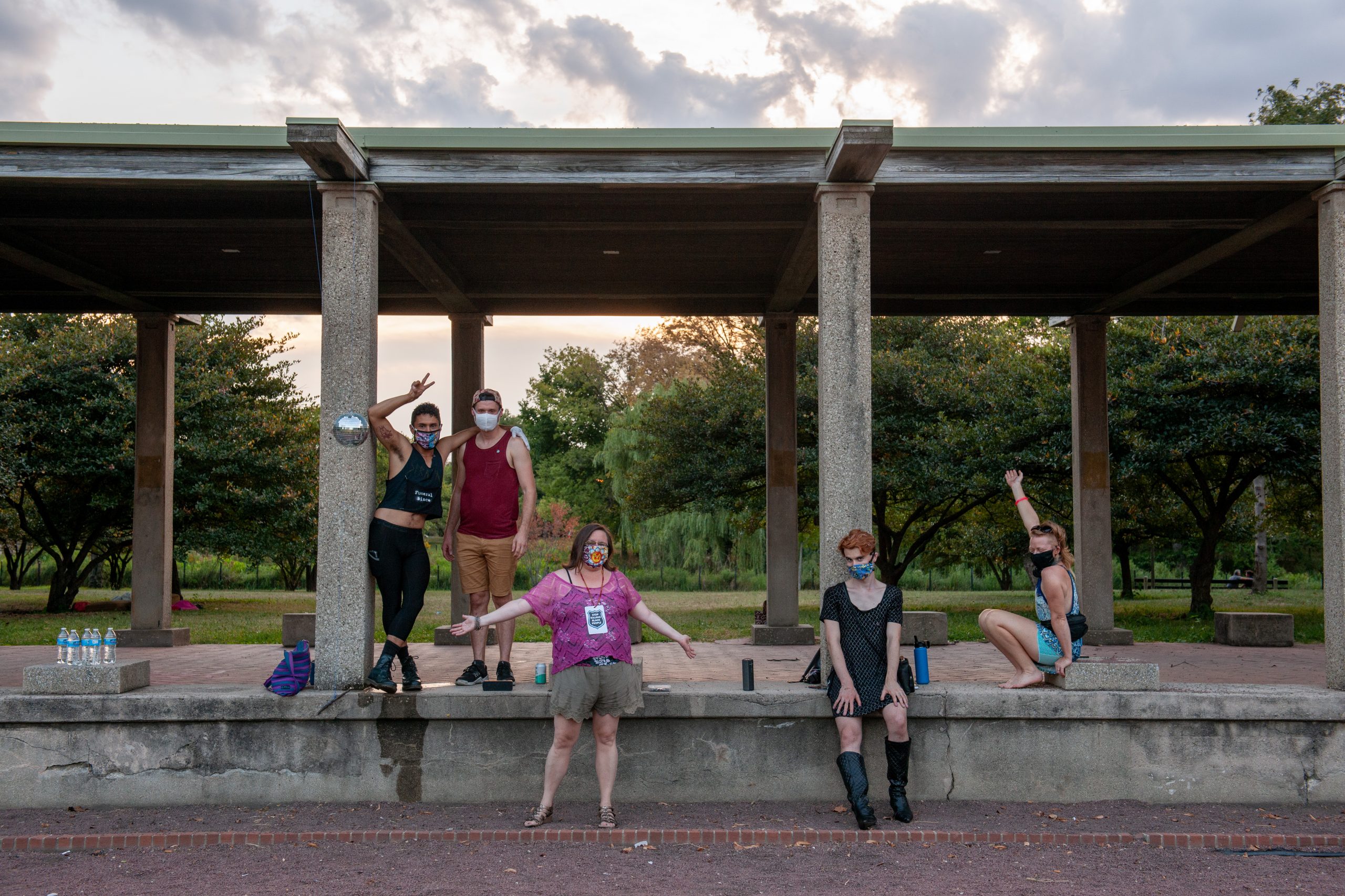 Image: A group of poets in various poses under and on a structure in Humboldt Park.