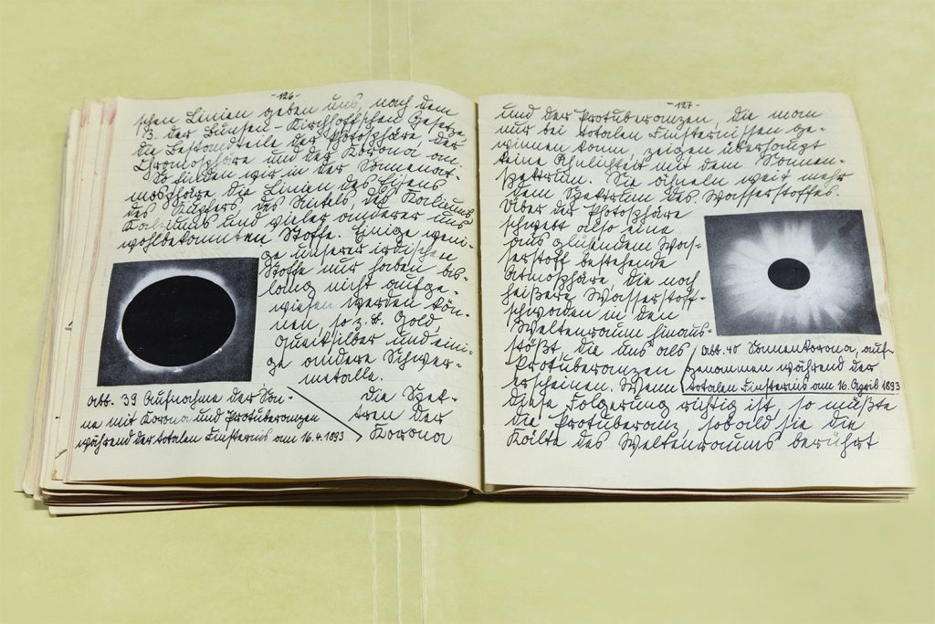 Image: Werner von Braun's Astronomy Manuscript, Written at Age 15, 1927/2019 by Barbara Diener. A photograph of an open journal with German writing on both pages and black and white photos of the moon. Image courtesy of the artist.