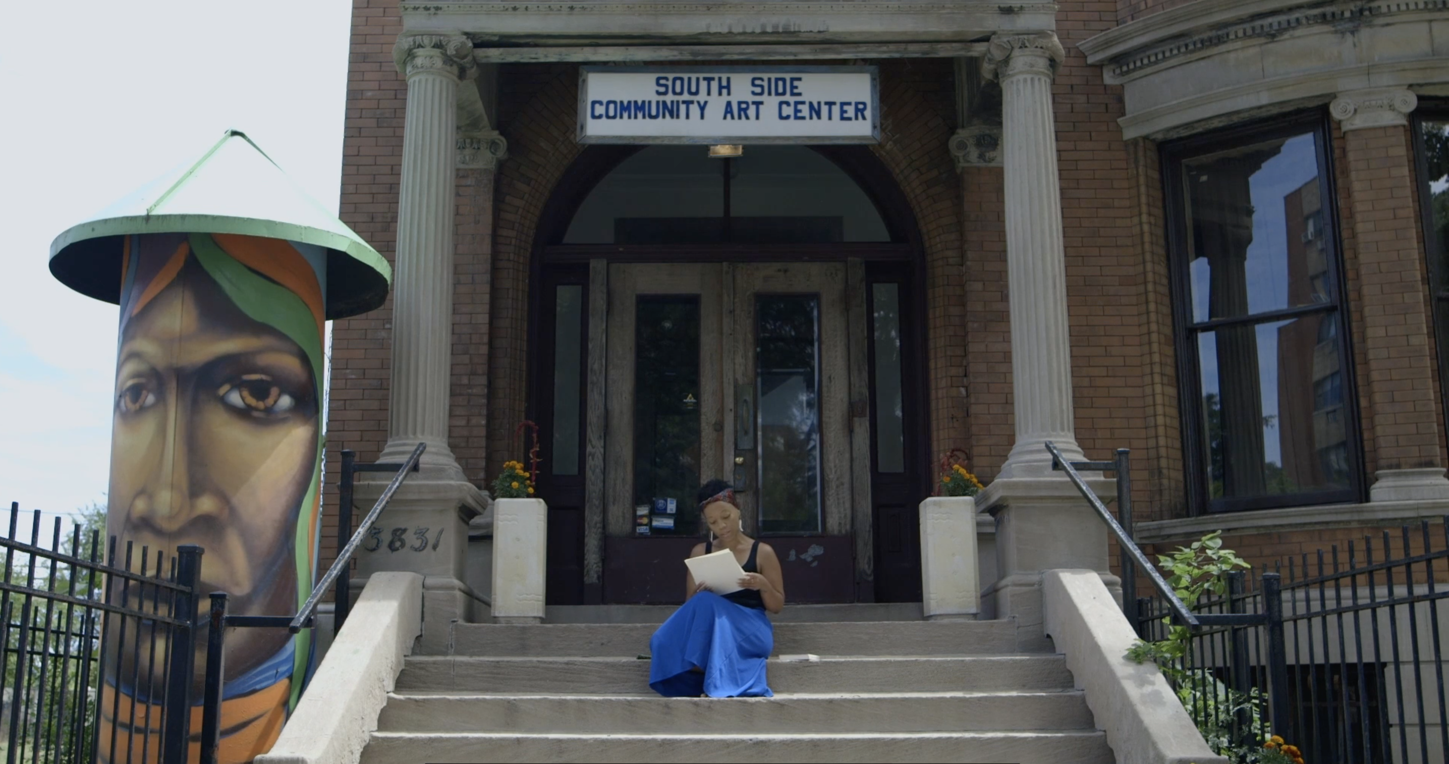 Still of Tempestt Hazel, sitting on the stairs of the South Side Community Art Center in Chicago. Photo by On the Real Film.