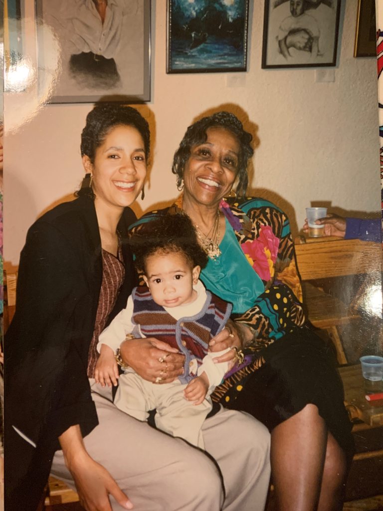 Image: Dorian and her oldest child Kahari with Abena Joan Brown. All three sit while smiling at the camera. Image courtesy of the artist.