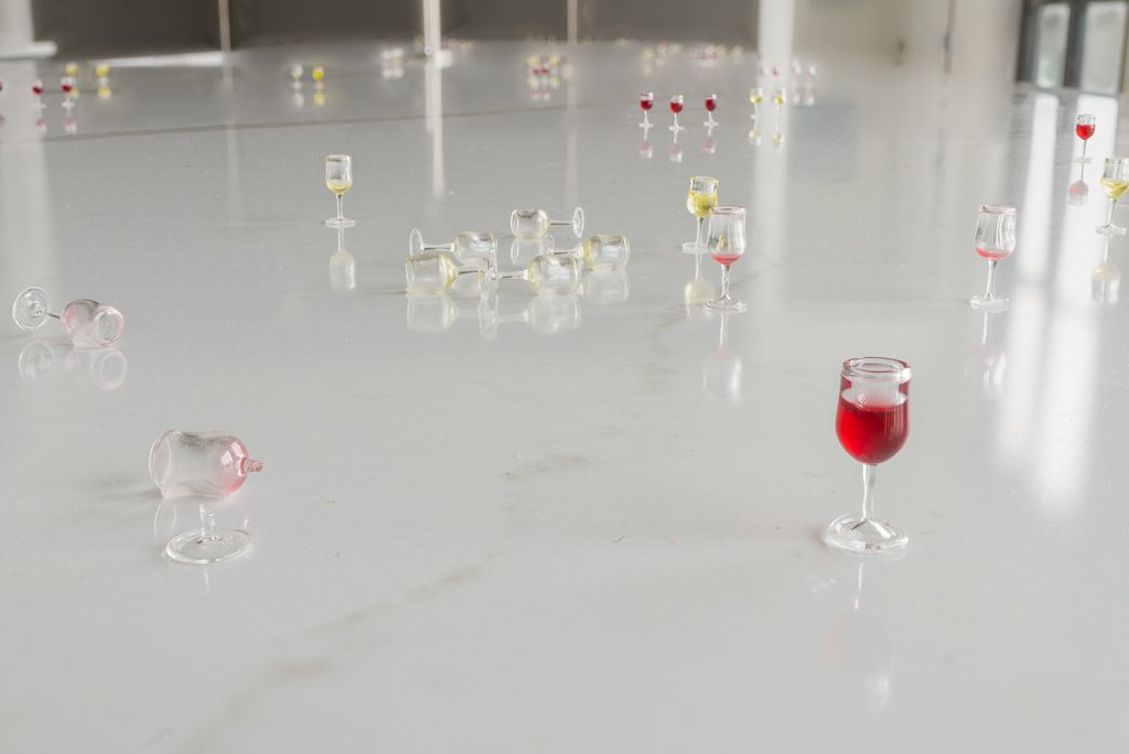 Image: Amanda Ross-Ho, installation view of Usual Objects. Untitled Opening (NOIR AND BLANCO). 2015. Thirty-five 1:12 scale glass wine glasses, pigmented resin, dimensions variable. Image courtesy of the artist and Carrie Secrist Gallery.