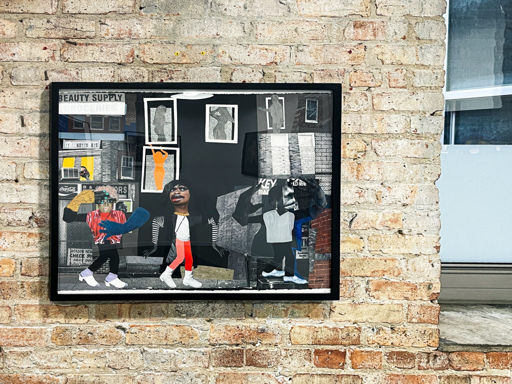 Image: An installation view of "Girls on the Avenue" by SHAN Wallace. Digital collage 30 x 24 x 1.75 inches (framed in black) (76.2 x 61 x 4.45 cm), 2021. The collage shows several figures in a city setting. Courtesy of the artist and FLXST Contemporary.