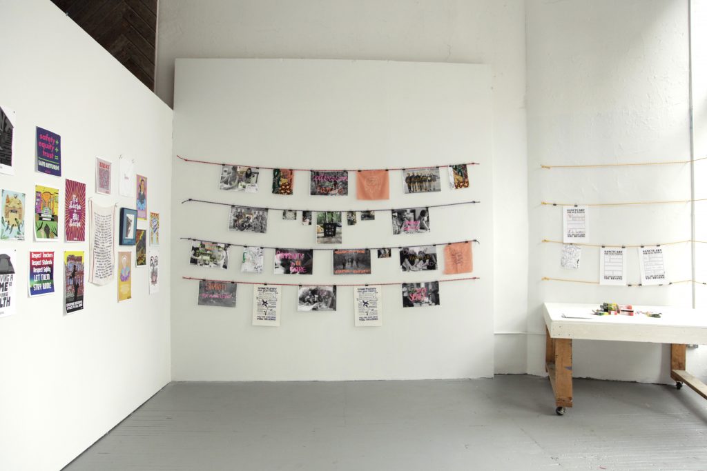 Image: Gallery walls with printed materials hung from strings affixed to the wall. Image courtesy of Silvia Inés Gonzalez.