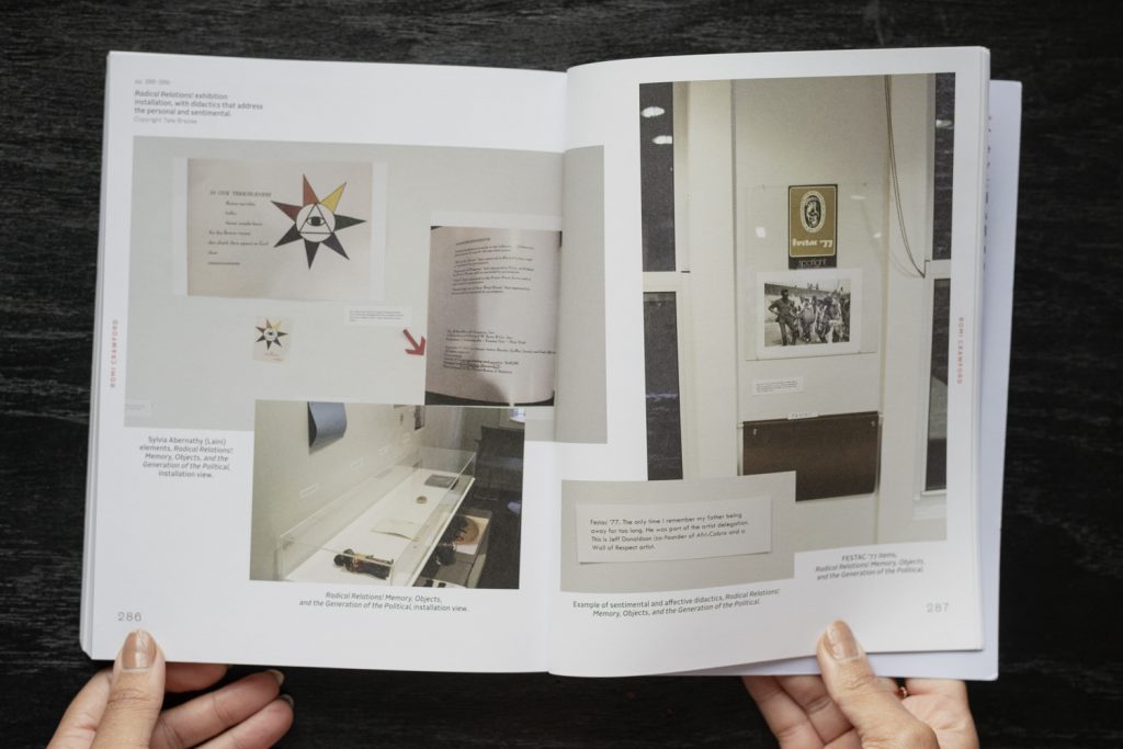 Image: The book Fleeting Monuments for the Wall of Respect is open to pages 286 and 287, showing a compilation of installation images by Tate Brazas from Romi Crawford's exhibition "Radical Relations! Memory, Objects, and the Generation of the Political". The images show didactics, ephemeral materials, objects in cases, and photographs from the exhibition. Photo by Ryan Edmund Thiel.