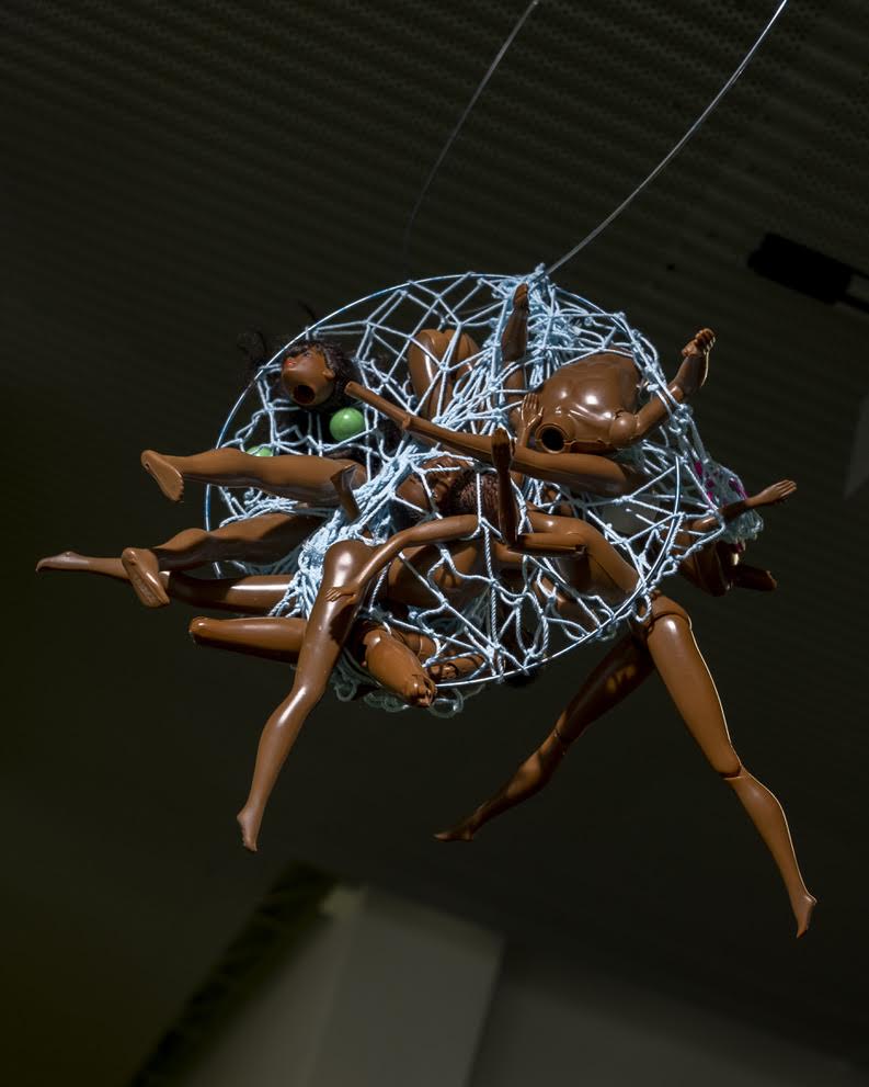 Image: A.J. McClenon, Wormhole Freedom Study: Ancestral Joy Hopping, 2021. Crabbasket, dolls. Dimensions Vary.  Doll limbs suspended in a light blue netting. Photo by Arda Asena, courtesy of curator Gervais Marsh.