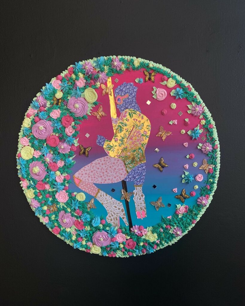Image: Maria Yolanda Liebana, Langston, 2021, mixed media collage, pattern paper, gold foil, plastic butterflies, mirrors, molding paste, neon paper, acrylic paint on wood panel, 24" x 24". A painting of a person dancing on a pole hangs on a black wall. The painting is circle in shape and highly textured with flowers bordering the figure. Image courtesy of FLXST Contemporary.