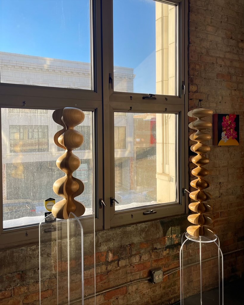 Image: An installation view of two sculptures by Vivian Chiu: Split Variation 5/4, 2021, poplar, laquer, 22 x 7 x 7"; Split Variation 11/4, 2021, poplar, laquer, 32 x 7 x 7". Image courtesy of FLXST Contemporary.