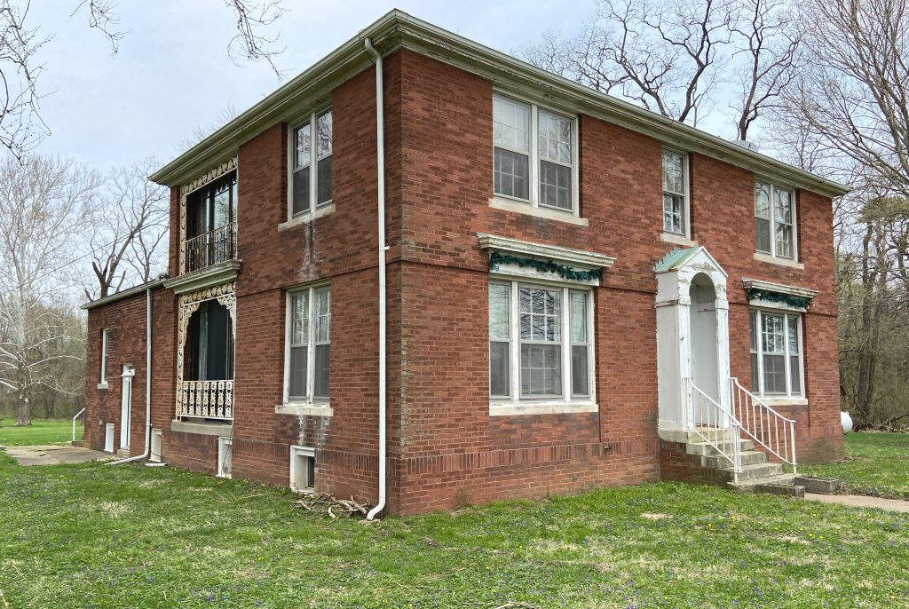 Image: A photo of the house where Anderson-Cobb and Bright stayed during their three-week residency at Allerton Park. The house is located near the Allerton barn, on the south side of the estate. It’s a two-story brick structure with flaking white trim. Only grass surrounds the house; there are no ornamental plants. Photo by Jessica Hammie. 