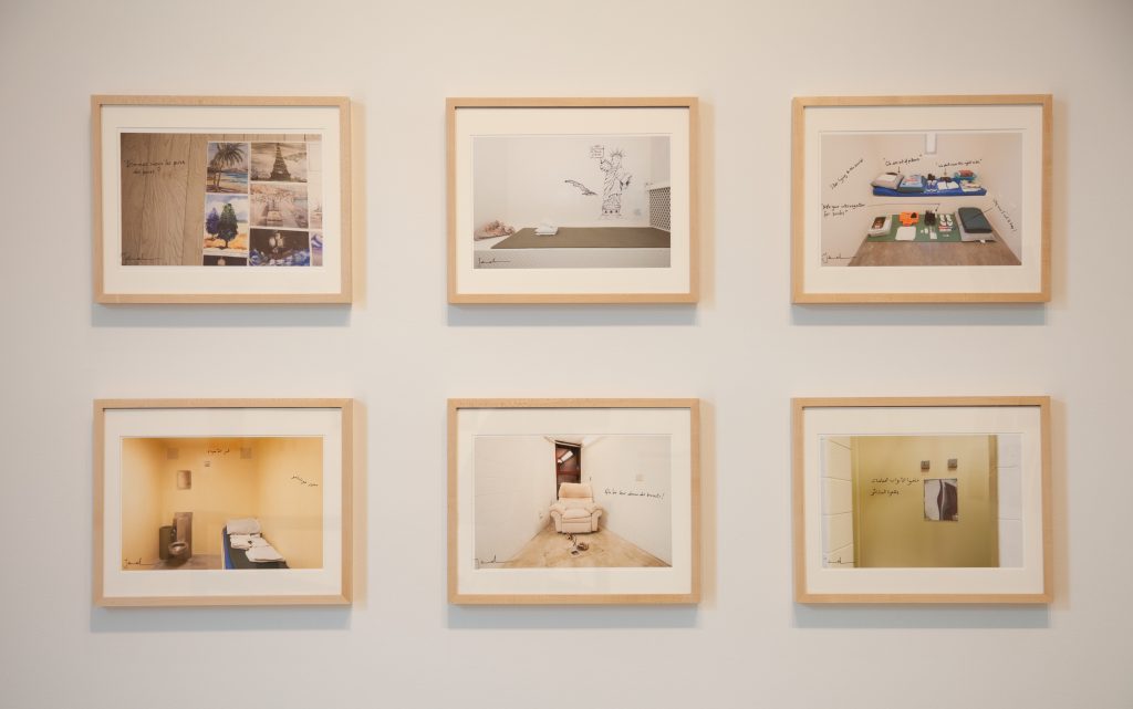 Image: The Annotating Gitmo series, 2015, by Debi Cornwall and Djamel Ameziane. Six framed photographs of cells and cell fixtures from Guantanamo Bay. Photograph by Zoey Dalbert. Courtesy of the DePaul Art Museum.