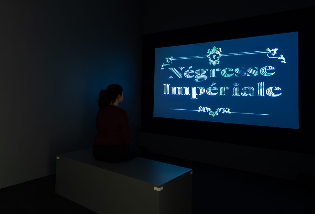 Image: In a small dark room the words Negresse Imperiale are projected onto a screen. Down Time: On the Art of Retreat, installation view, Smart Museum of Art, The University of Chicago, October 25–December 15, 2019. Photo by Michael Tropea.