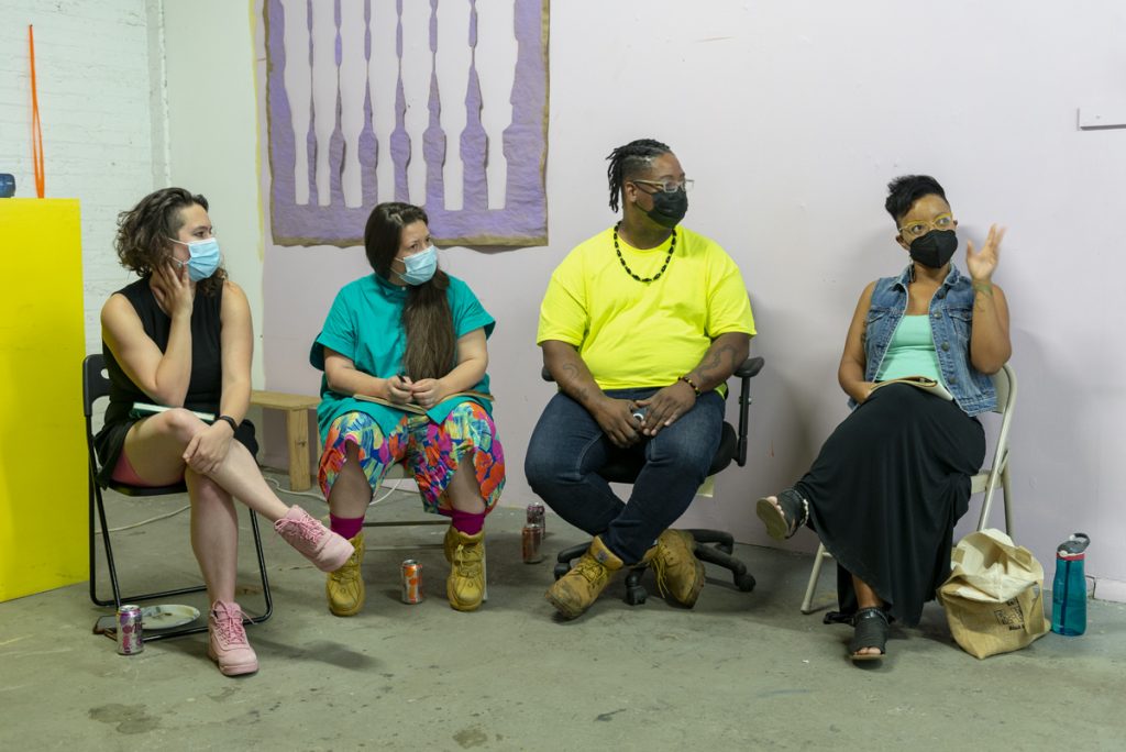 Image: A photo of the second session of CANJE. Four Sixty folks sit in chairs while discussing the work of Rainn Thomas. From left to right: Morgan Green, Natalia Villanueva Linares, EdVette Jones, and Tempestt Hazel. The presenting artist was Rainn Thomas and the special guest was J Kent. Photo by Ryan Edmund Thiel.