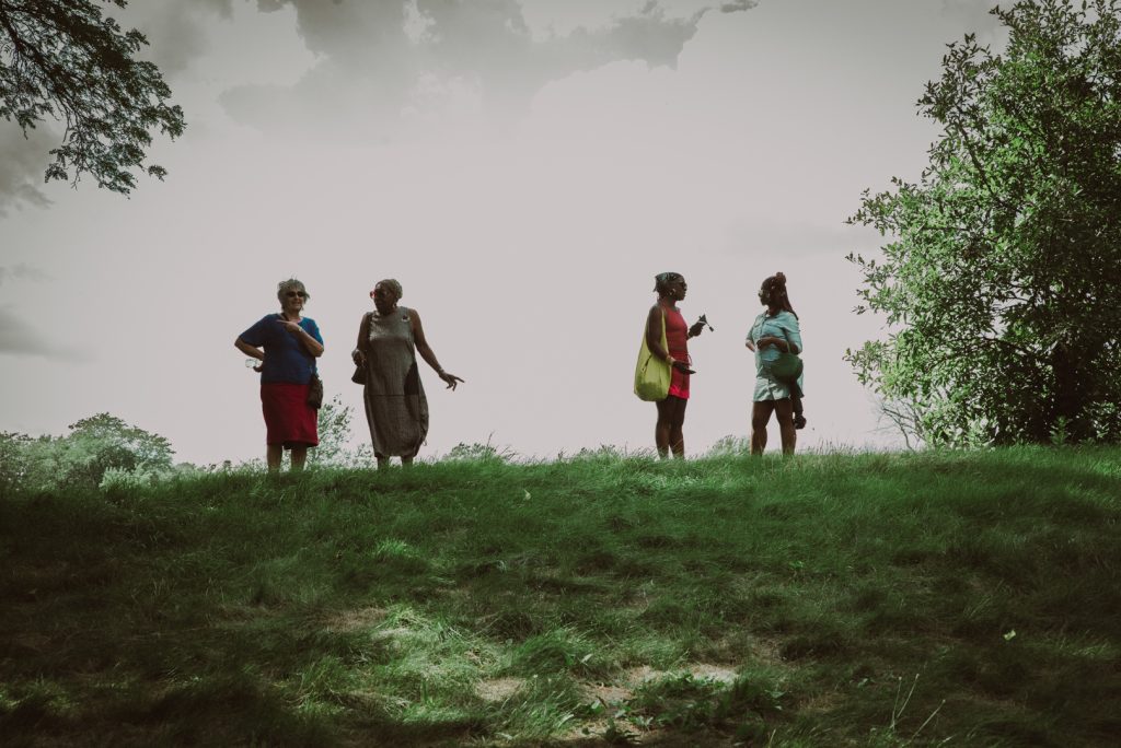 Image: Four women talk on the top of a hill after the tour. Photo by EdVetté Wilson Jones.