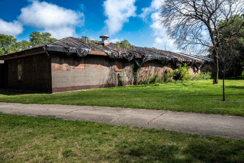 Image: An abandoned structure that once served as a recreational building sits off a path. Photo by EdVetté Wilson Jones.