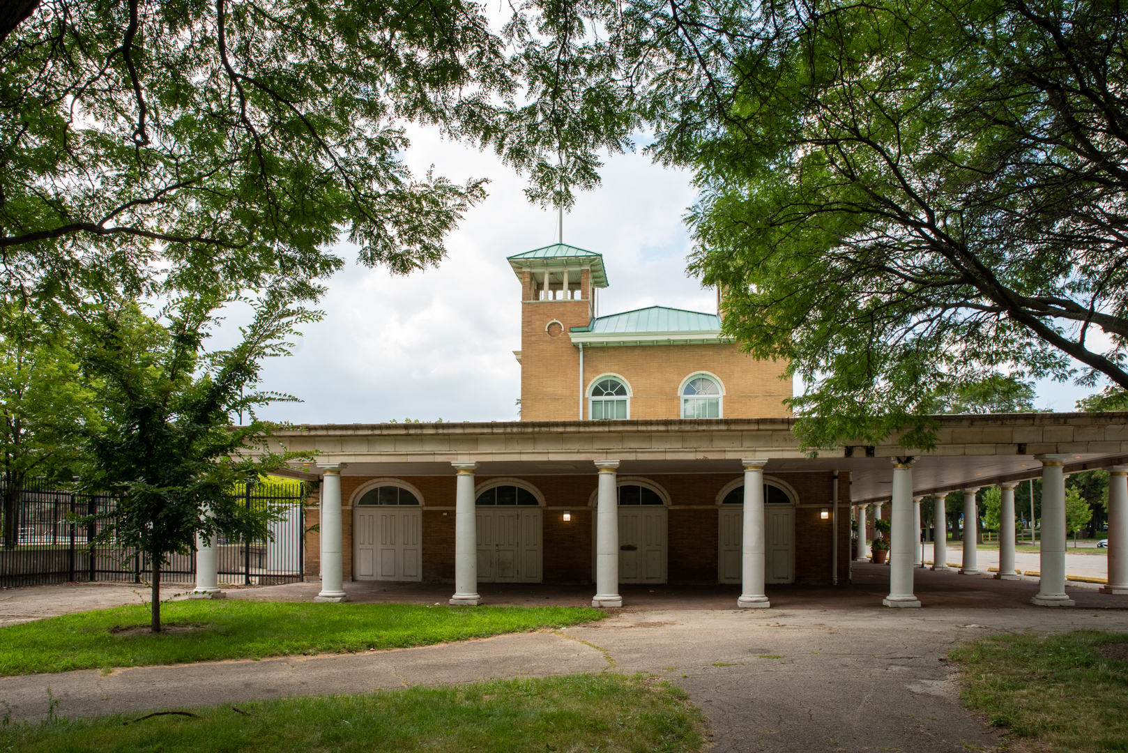 Image: The Washington Park field house, built in 1891, at the western entrance to the park. It is a multi-story brick building with columns and a covered walkway around it. Photo by EdVetté Wilson Jones.