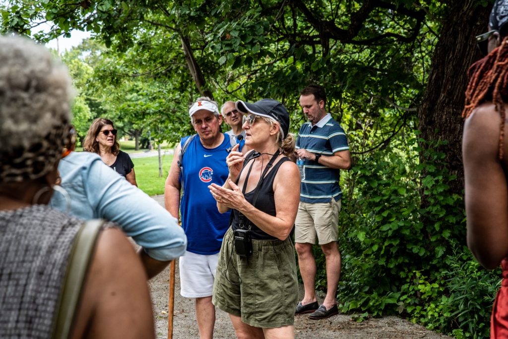 Image: The tour guide talks with tourists as they stop on a path in the park. Photo by EdVetté Wilson Jones.