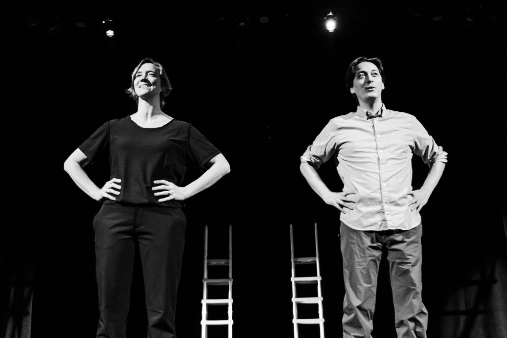 Image: Greyscale image of Melinda Jean Myers and Kurt Chiang, standing a person apart from each other, both with their hands on their hips. Behind each of them is a ladder. Photo by Ella Kang.