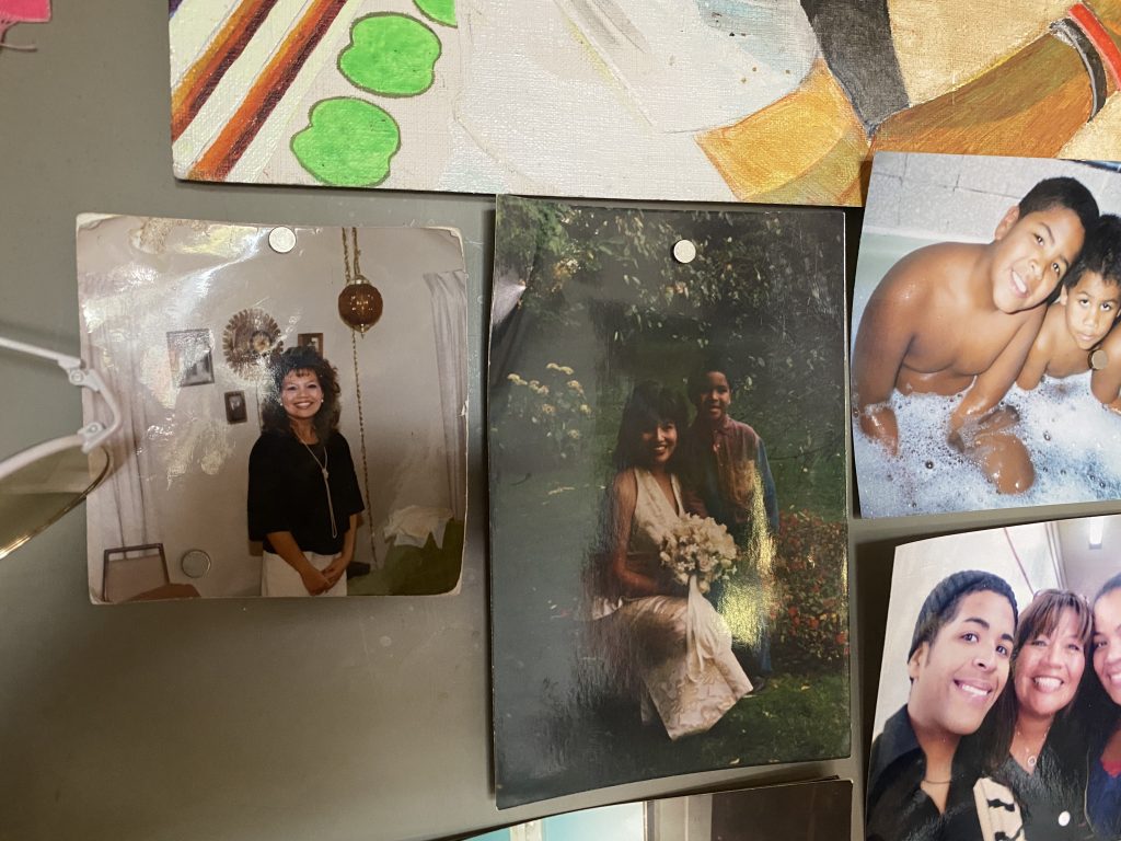 Image: Snapshots in Erol's studio during the interview. A view of Erol's studio door, where there hangs a series of family photos, notes, and drawings. The photo focuses on photos of Erol's Aunt Christina. Photo by Tempestt Hazel.