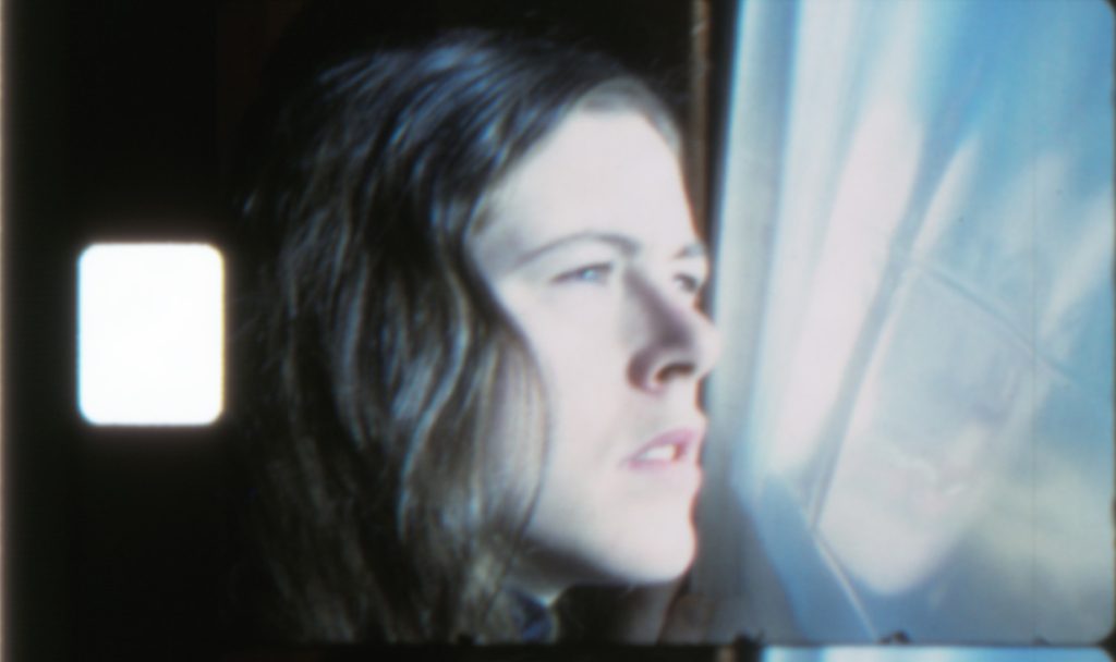 Image: Still from the film Five Year Diary. A young woman in profile stares out of a window. Courtesy of the Anne Charlotte Robertson Collection, Harvard Film Archive, Harvard University.