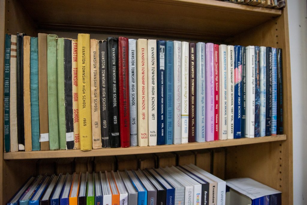 Image: A bookshelf at the Shorefront Legacy Center filled with Evanston Township High School yearbooks, mostly from the 60s and 70s. Photo by Edvetté Wilson Jones.