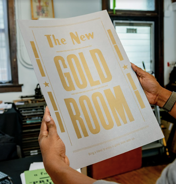 Image: A flyer that reads "The New GOLD ROOM" in gold ink, handmade my Ben Blount. Photo by Ryan Edmund Thiel