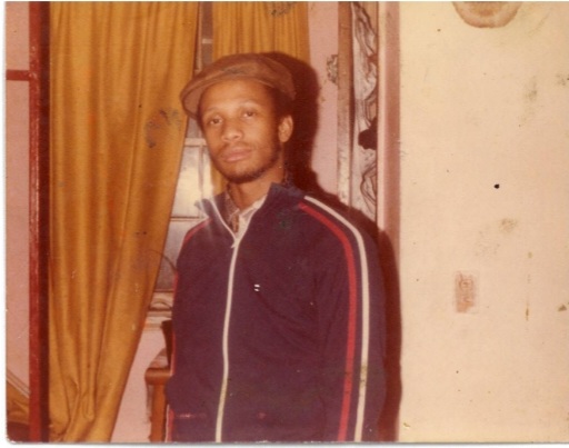 Image: Jerome in his 20s wearing a black striped jacket and brown cap. Courtesy of Alkebuluan Merriweather and their father.