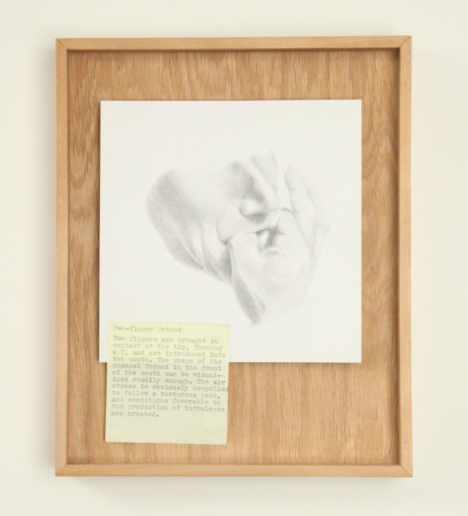 Image: Gala Porras-Kim, Notes after G. M. Cowan 10, 2012. A graphite sketch of the lower half of a person's face with their fingers in their mouth to whistle. The sketch is attached to a wooden board and a yellow post-it note detailing the "two-finger method" of whistling is attached to the lower left corner of the sketch. Image courtesy of DePaul Art Museum, Art Acquisition Endowment Fund.