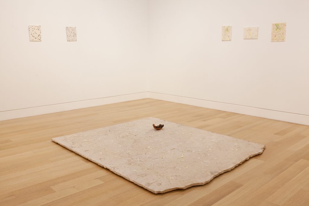 Image: Harold Mendez, Let us gather in a flourishing way, 2016. Installation view of a travertine, oxidized copper reproduction of a pre-Columbian death mask from the Museo del Oro sits on a large piece of marble on the ground in the middle of the gallery space. Image courtesy of Collection of DePaul Art Museum, Art Acquisition Endowment Fund.