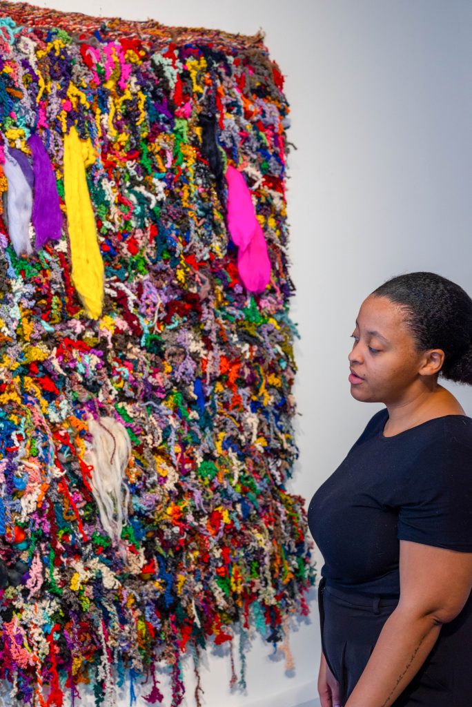 Image: Portrait of Bryana Bibbs and her "Alone Against It All," 2022.
Approx. 5.5’ x 5.5.’ Handwoven, hand-carded, hand-spun wool, bamboo fiber, angelina fiber, nylon fiber, and recycled sari silk. Photography by Tonal Simmons.
