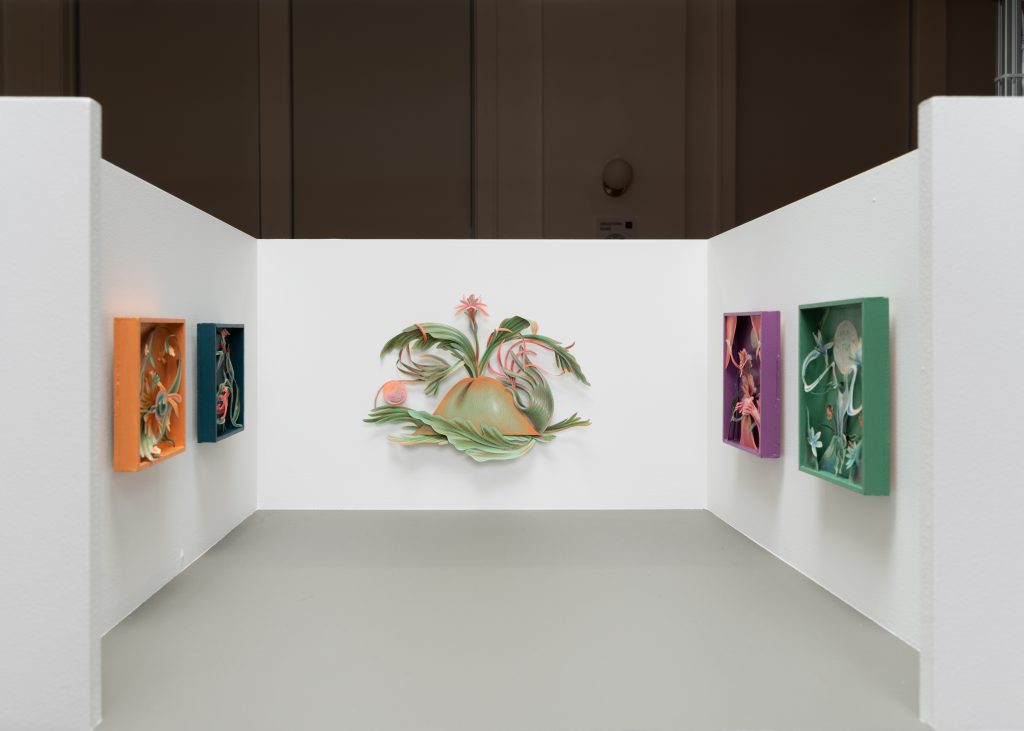 Image: An installation shot of Patel Brown's booth at Barely Fair, featuring five works by Winnie Truong. Two framed cut-paper pieces hang on the left and right walls, while the largest piece hangs unframed on the back wall. The works are organically shaped and nature-esque. Photo by roland miller.