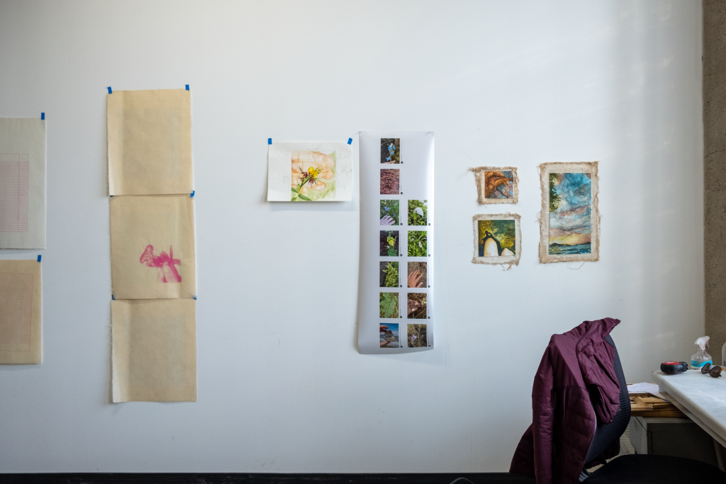 Image: Artist Kushala Vora's studio. A variety of prints, paintings, and drawings taped on the wall. Photo by Saadia Pervaiz