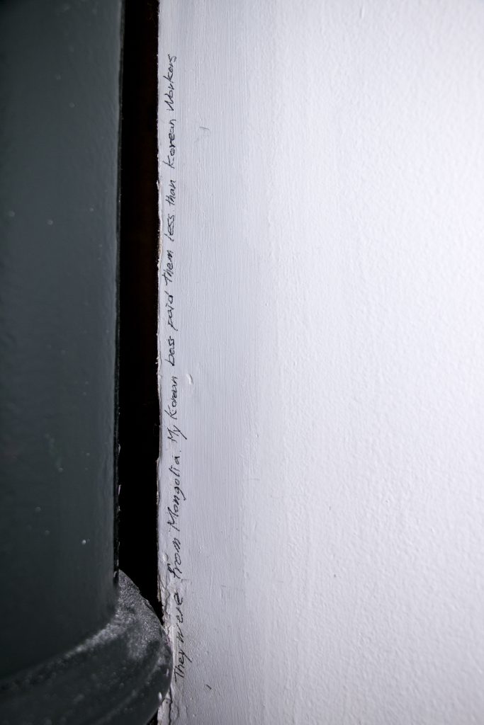 Image: To Document Better Secrets – US. Version (detail).
2018. Site-Specific Installation: 30 writings on the exhibition space and 30 prints of the writing adhered on the space. Digital Print 12 x 18. Courtesy of the artist.